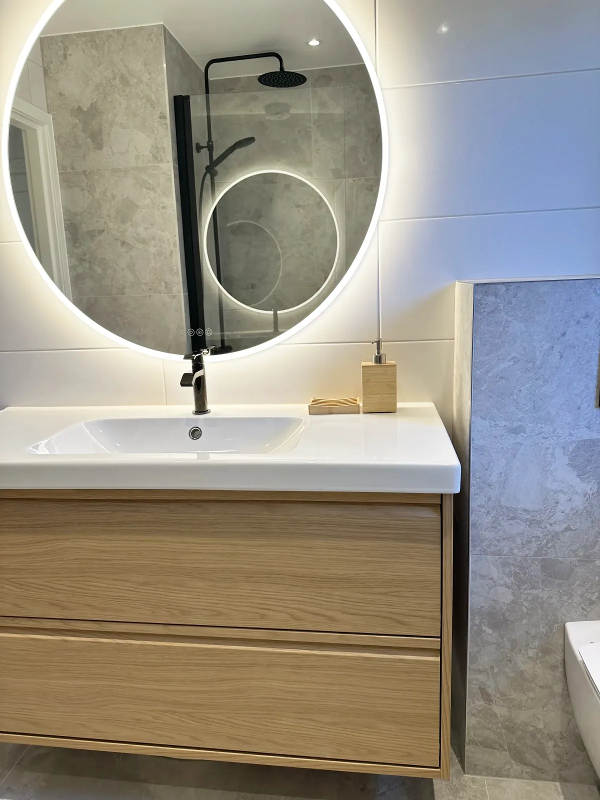 Badrumsrenovering i Järfälla med handfat, kommod och vägghängd wc