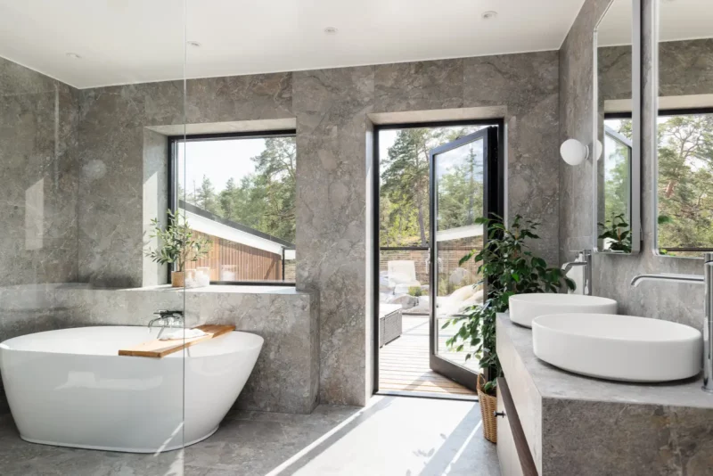 Badrumsrenovering i Stockholm med fristående badkar och grå klinker