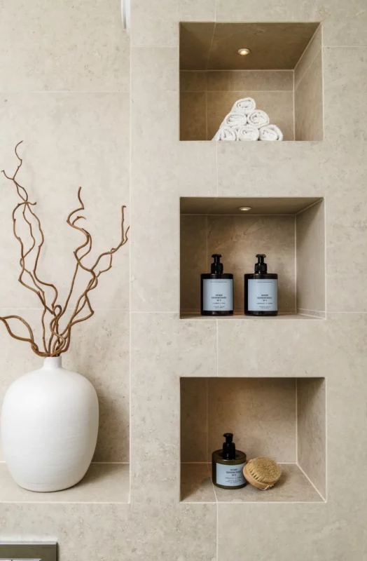 Stilren badrumsnisch i keramikgranit med inbyggd belysning och detaljer vid badrumsrenovering i Stockholm